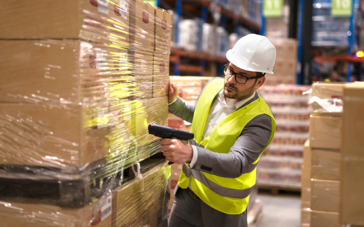 male-warehouse-worker-using-bar-code-scanner-analyze-newly-arrived-goods-further-placement-storage-department 1